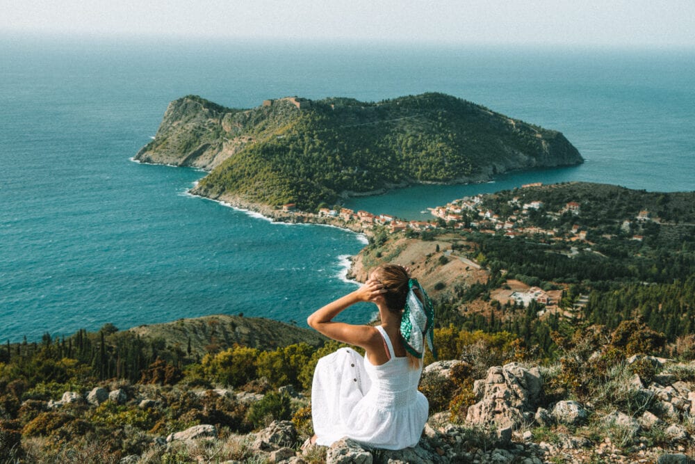 Travel Guide to Kefalonia, view over Assos town, Assos Castle and dense green foliage.