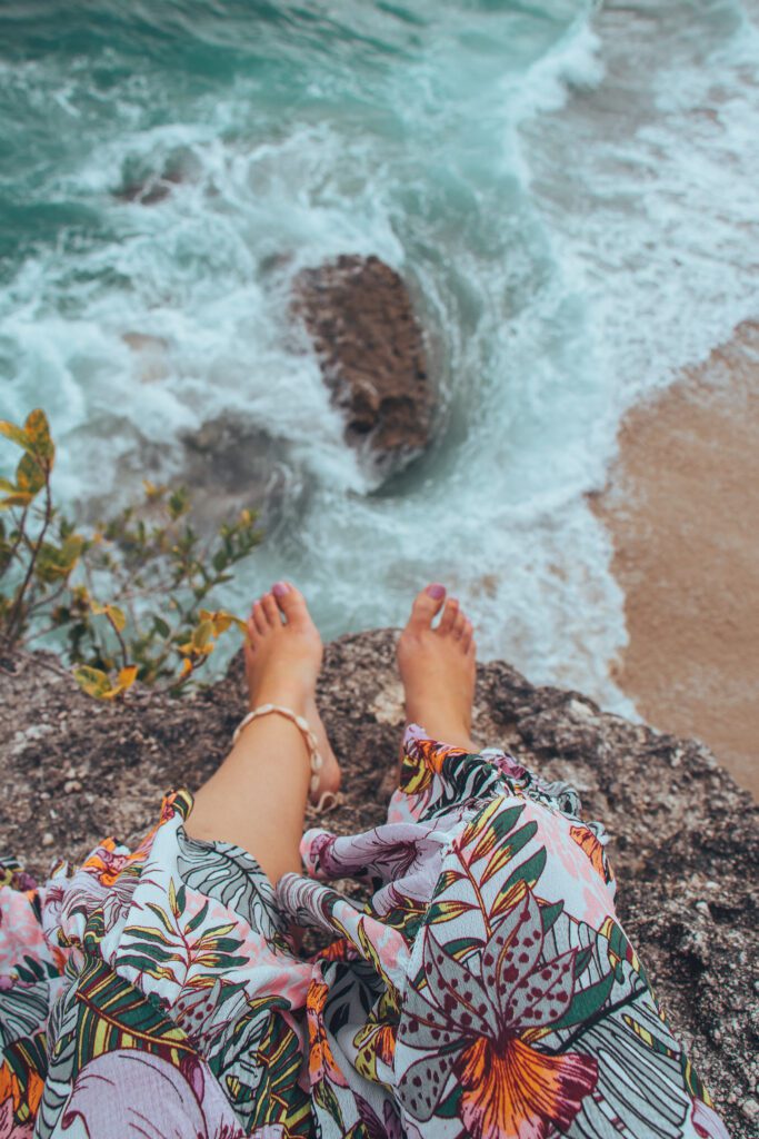 Girls feet hanging over Nusa Lembongan Secret Beach view point